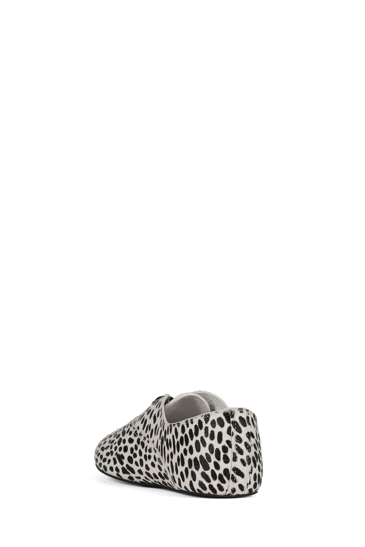 Leopard print slip-on flat shoe with a rounded toe, low heel, and open collar in a bold black and cream spotted pattern
